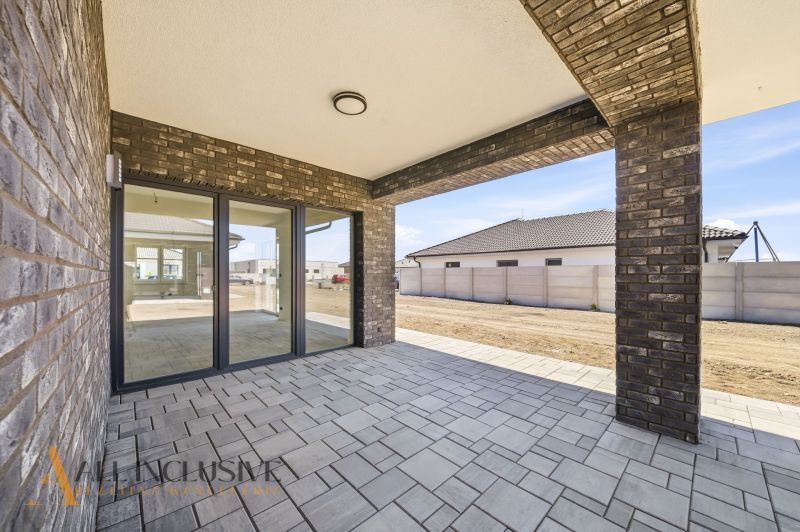 The terrace of a family house in Hviezdoslavov, lined with bricks and offering a beautiful view of the yard.