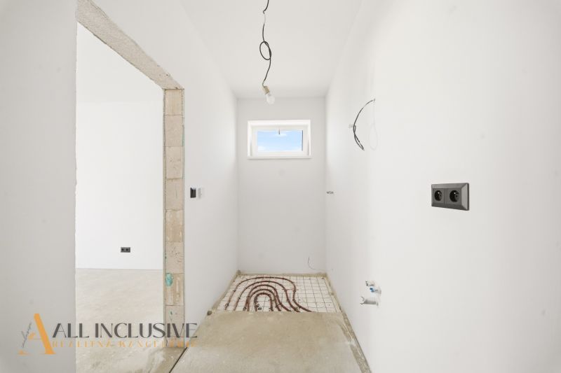 An empty room with white walls and preparation for underfloor heating in a family house.