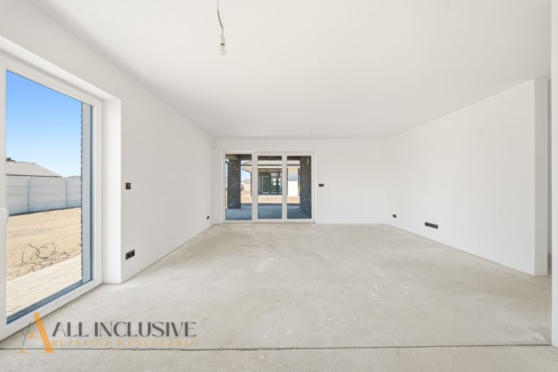 A spacious room in a family house with large windows and light walls.