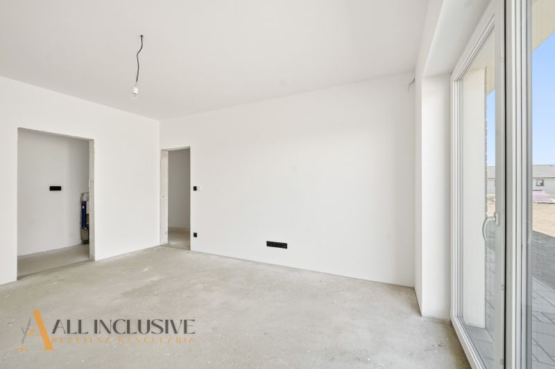 The interior of a family house with white walls and a large window without flooring.