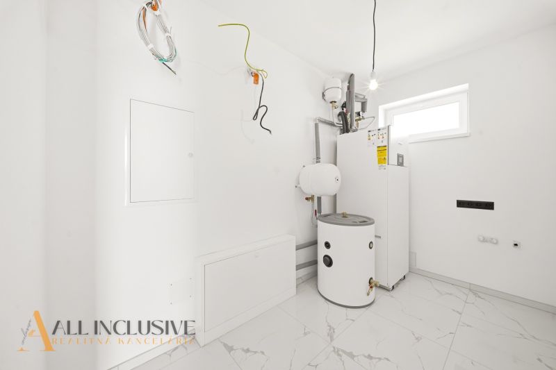 Technical room with a boiler in a family house with white walls and ceramic tiles.