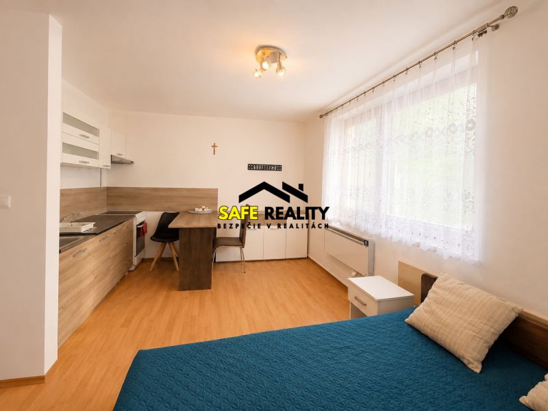 Bright studio apartment with a kitchen and a bed, floor with wooden decor.