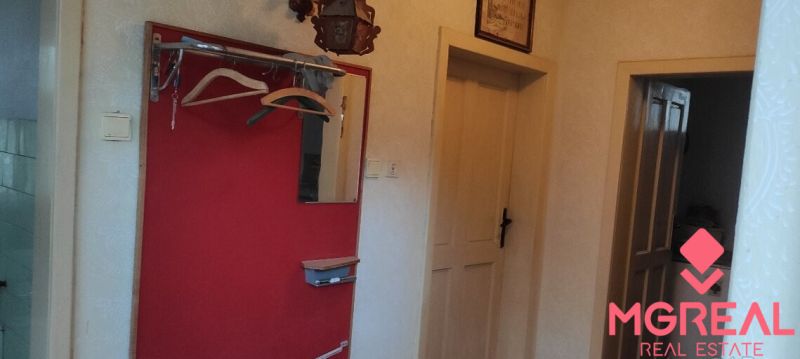 A hallway in a family house with a coat rack and doors to the rooms.