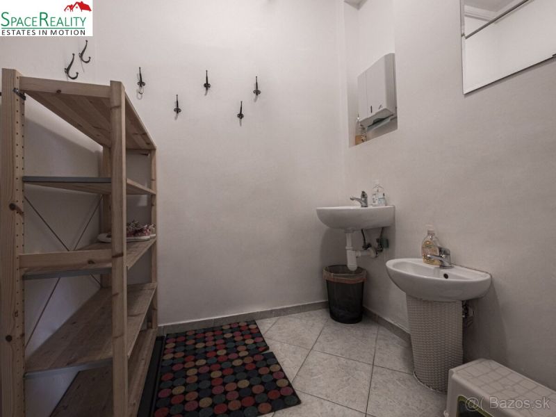 A bathroom in a 3-room apartment with sinks, a mirror, a shelf, and tiles.