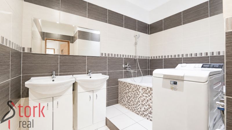 A bathroom in a 3-room apartment with a shower, bathtub, and tiles in earthy tones.
