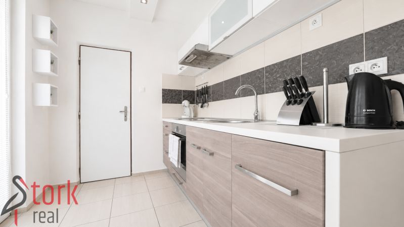 A kitchen with a wooden decor floor in a 3-room apartment.