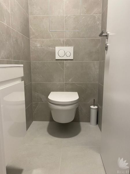 Bathroom with toilet and simple white tiles in the office.