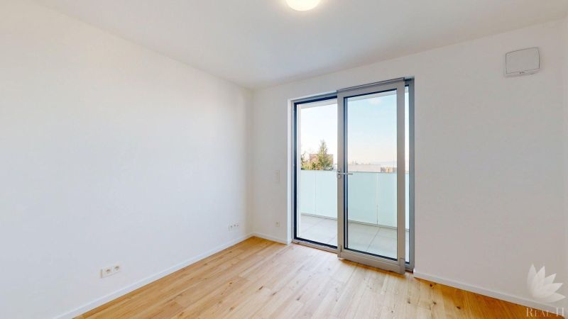 An empty room with a wooden floor decor and balcony doors in offices.