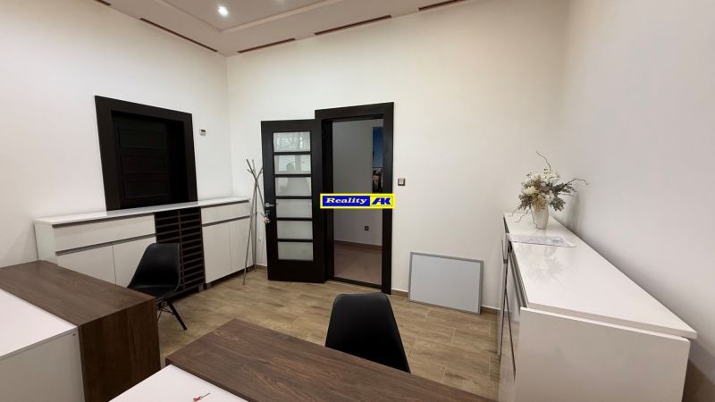Interior of an office with wooden decor, modern furniture, and decorations on the desk.