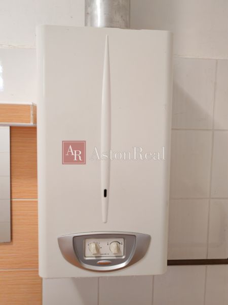 Gas boiler in a family house with a white interior and tiles.