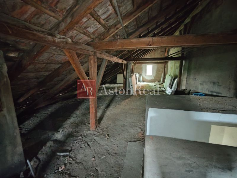 The attic in the family house with scattered building materials on the floor.
