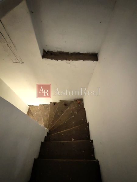 A staircase leading to the basement in a family house with white walls.