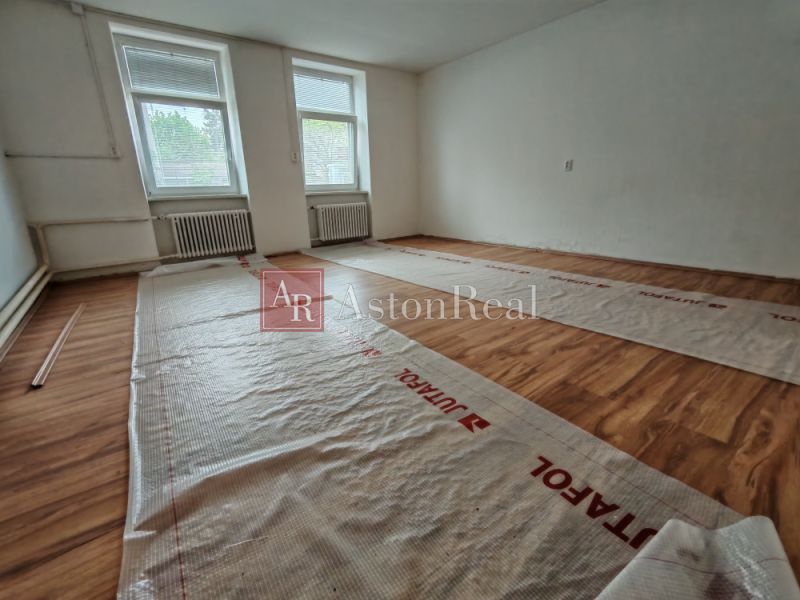 A room with a wooden decor floor in a family house, ready for renovation.