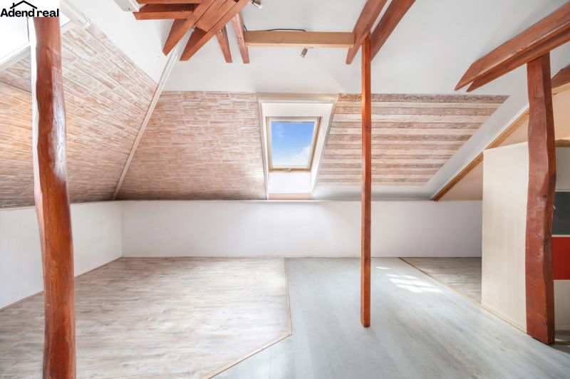 An attic in a family house with a window and a wooden decor floor.