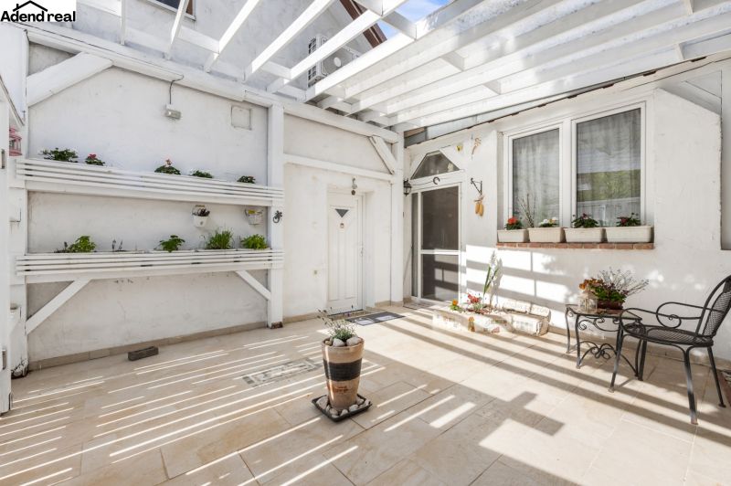 The courtyard of the family house on Robotnícka Street in Tomášov with a terrace, flower pots, and seating.