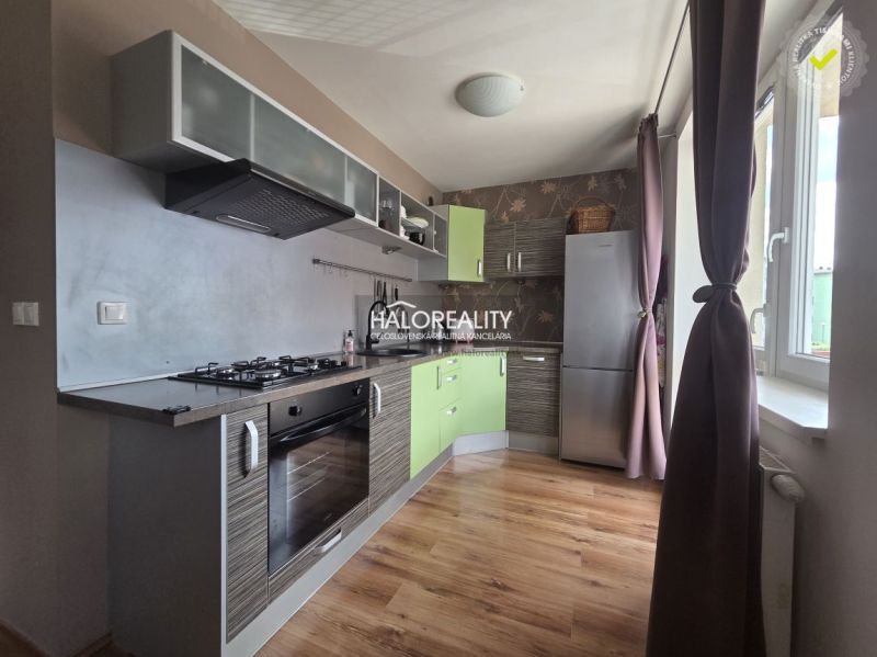 A kitchen in a 2-room apartment with a wood-patterned floor and modern appliances.