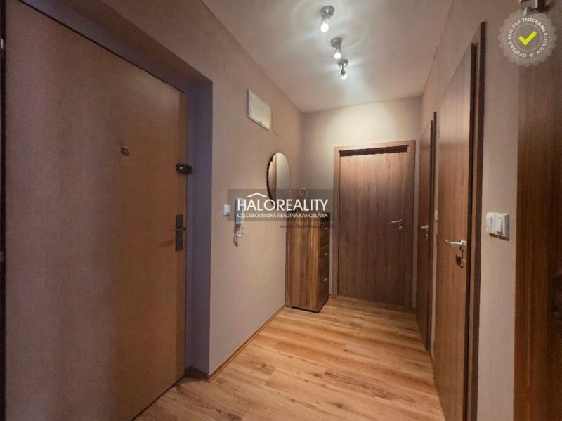 Entrance hallway in a 2-room apartment with a wooden decor floor and wooden doors.