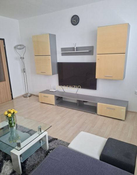 Living room with a TV, wooden decor flooring, a sofa, and a coffee table in a 3-room apartment.