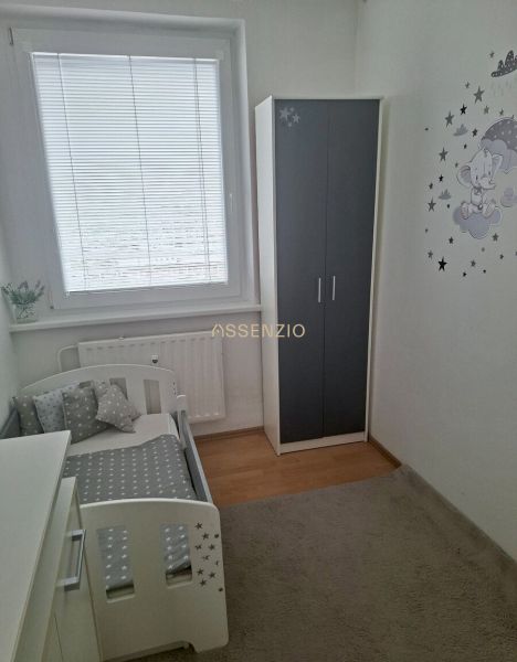 Children's room with a bed and a wardrobe in a 3-room apartment with a wooden decor floor.