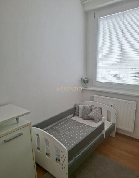 Children's room in a 3-room apartment with a bed and a wooden decor floor.