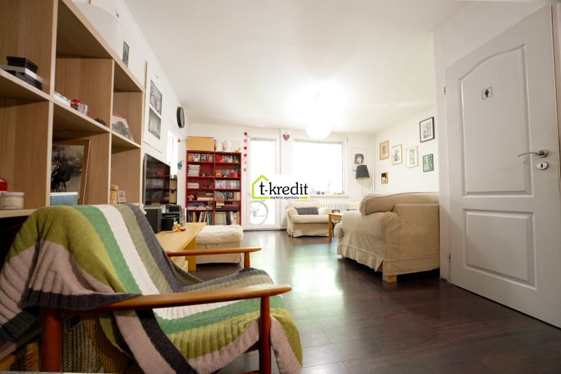Living room in a 3-room apartment with a wooden decor floor and comfortable seating.