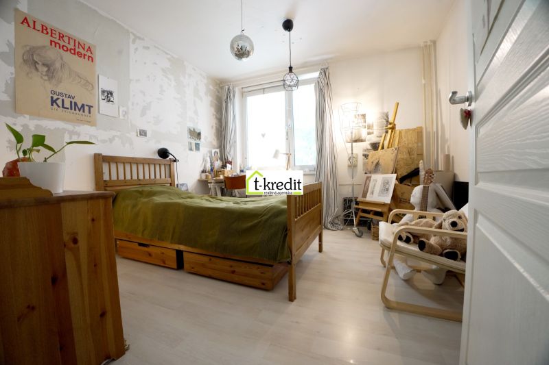 Bedroom in a 3-room apartment with space for creative work and a floor with a wooden decor.