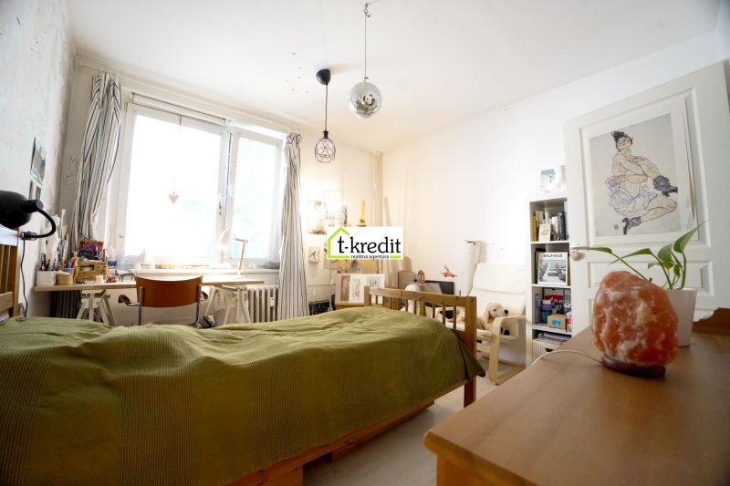 Bedroom in a 3-room apartment with wooden decor furniture, a desk, and decorations.