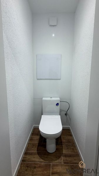 WC with a wooden decor floor in a 3-room apartment.