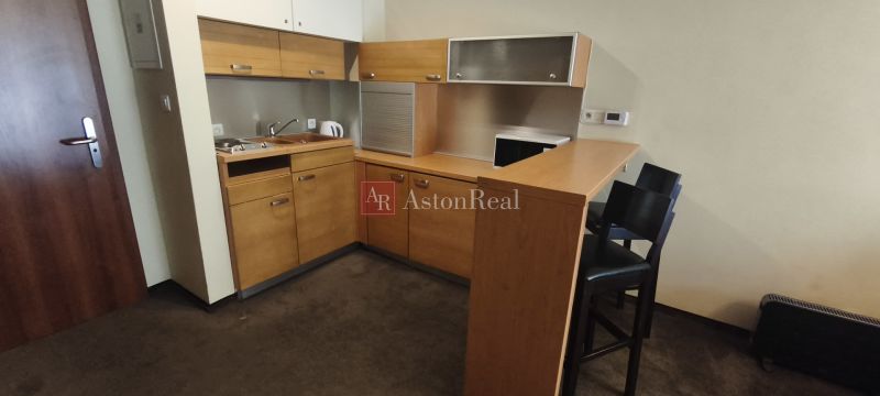 A kitchen in a holiday apartment with wooden cabinets and a bar counter.