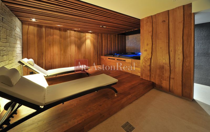 Relaxation area with loungers, wooden elements, and flooring with a wooden decor in a recreational apartment.