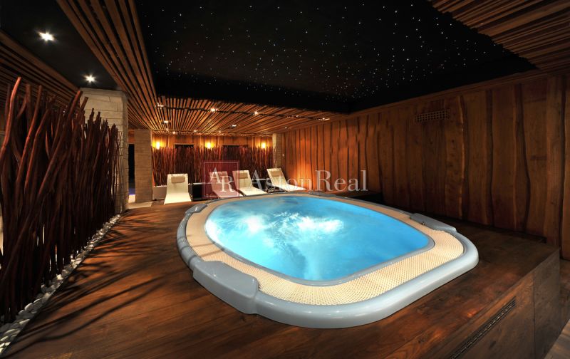 Luxury wellness in a recreational apartment with a hot tub and a floor with wooden decor.
