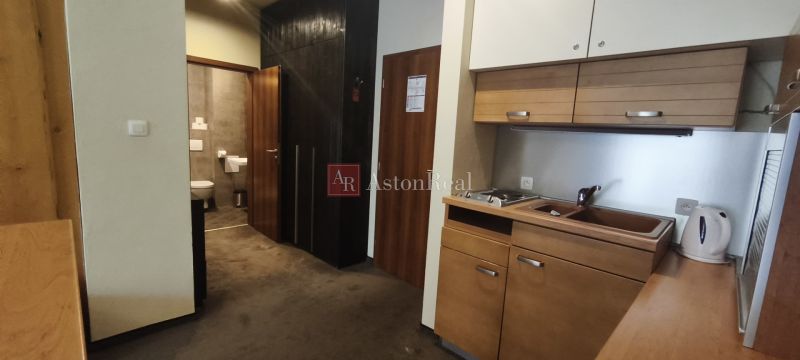 Kitchen corner with cabinets and a sink in a holiday apartment, next to the entrance to the bathroom.