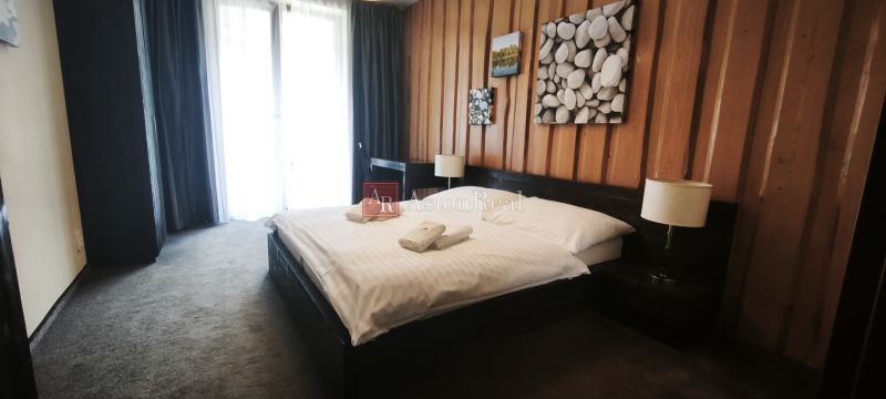 Bedroom with a double bed and decorative paintings in a holiday apartment.