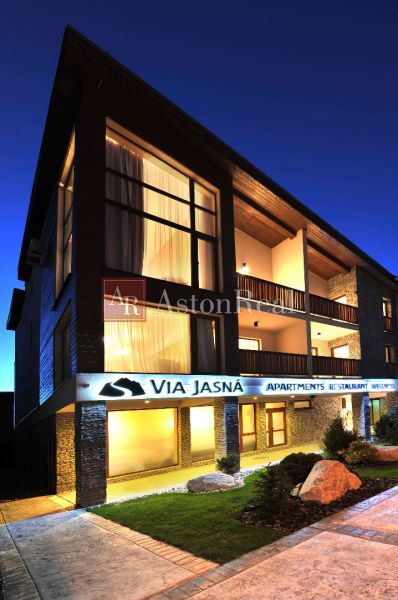 The exterior of a holiday apartment in Demänová on Demänová Street at dusk.