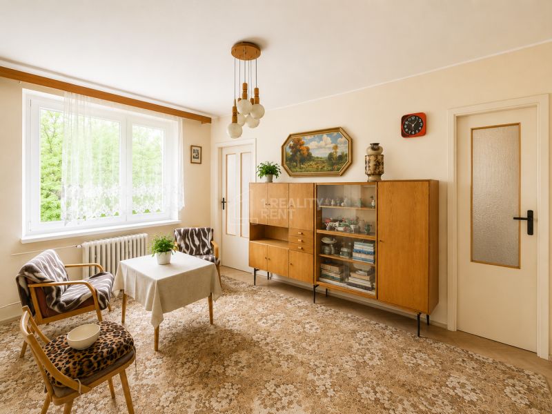 Living room in a 3-room apartment with retro furniture and a large window.