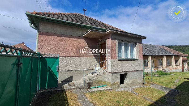 A family house in Veľké Kršteňany with a hallway and staircase, surrounded by a green fence.