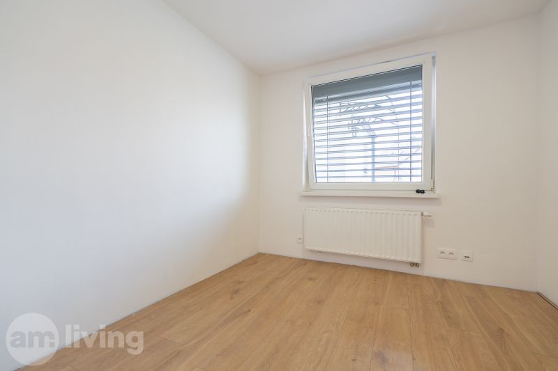 A room in a family house with white walls and a wooden decor floor.