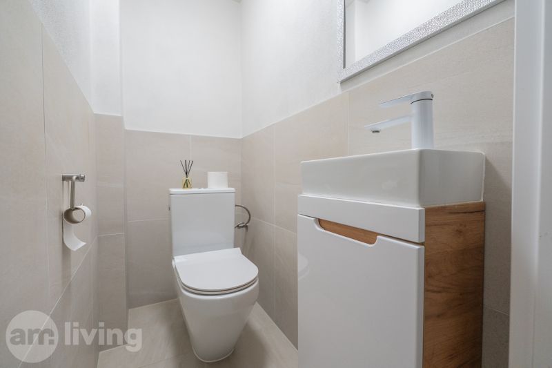 Bathroom with toilet and sink in a family house with wooden decor.