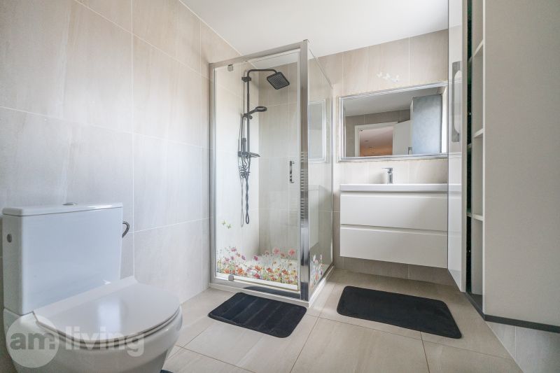 A bathroom in a family house with a toilet, shower, and sink.