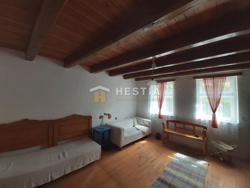 Interior with wood-patterned flooring, simple furniture, and a wooden ceiling.