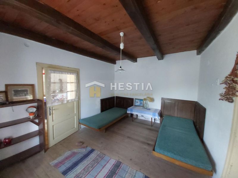 A room with a wooden ceiling, two beds, and a shelf, Land - living.