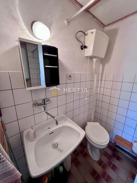 Bathroom with sink, mirror, and toilet. Suitable for residential plots.