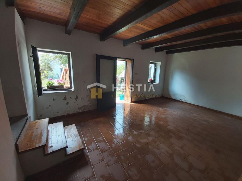 Interior with ceramic tiles, wooden ceiling, and garden view. Properties - living.