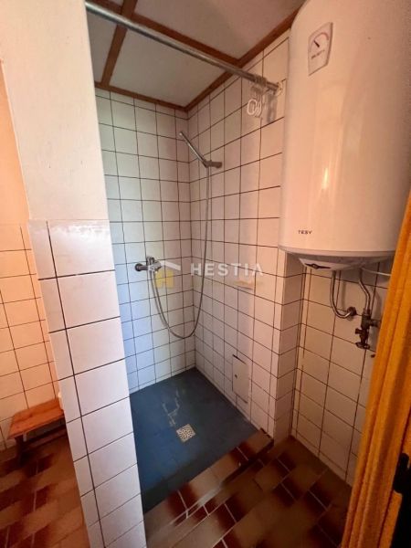 Bathroom with white tiles and a shower, offered on Residential Land.