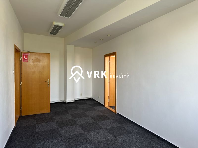 Room with carpet flooring and wooden doors in corporate offices.