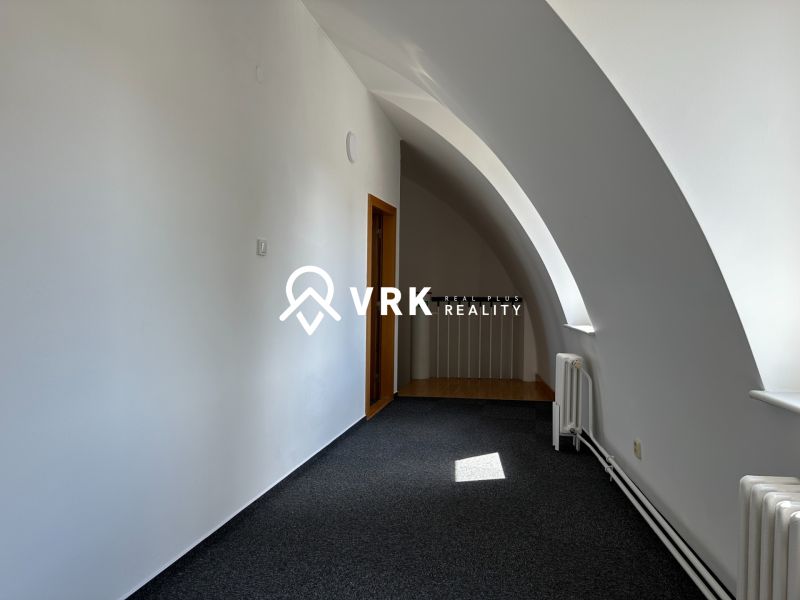 The interior of an office with carpeted flooring and an arched ceiling.