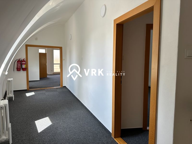 Offices with arched ceilings, white walls, and dark carpet in the interior.