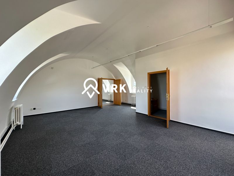 Offices with arched ceilings and carpet, white walls, and wooden doors.