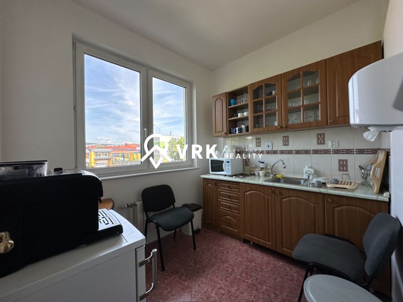 Office kitchen equipment with a view, cabinets, and appliances.