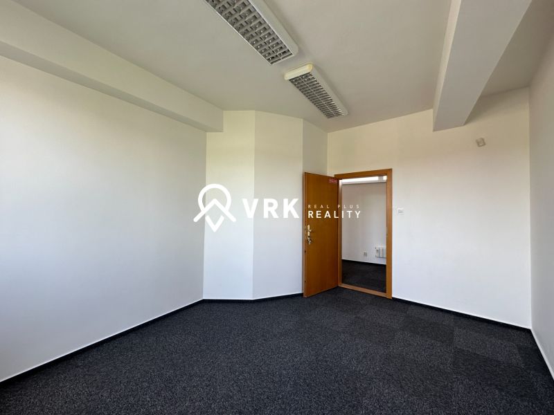 Offices with white walls and dark carpet, doors with wood decor.